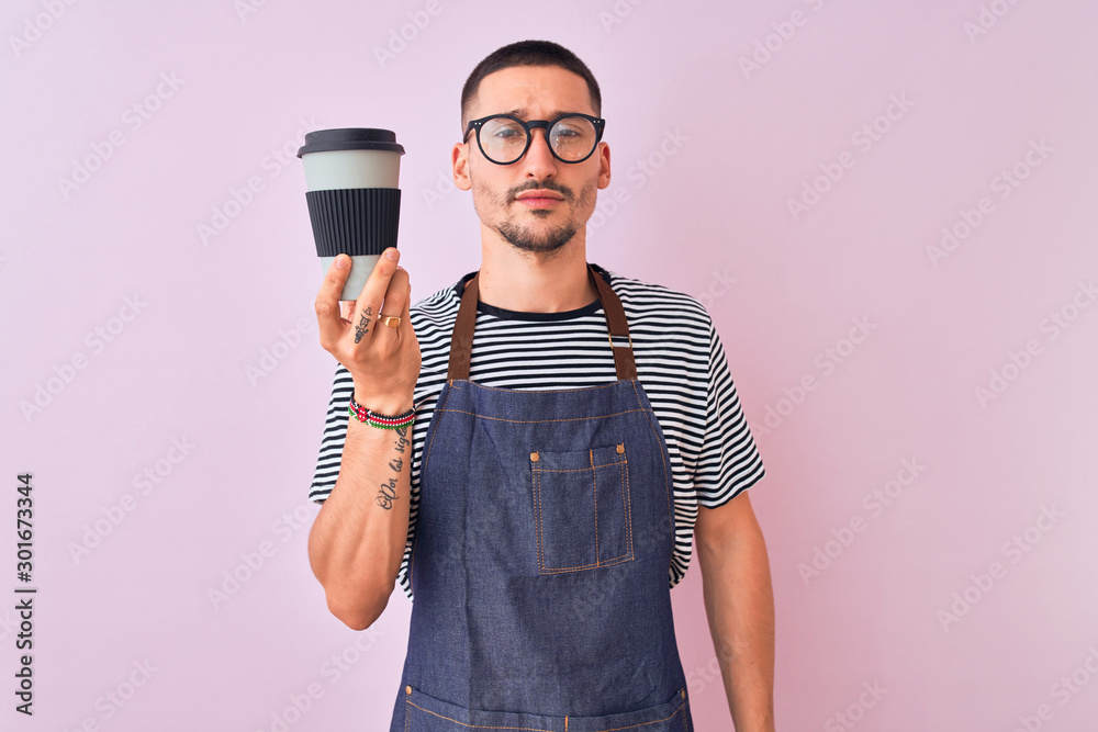 Young handsome barista man wearing uniform over isolated background with a confident expression on smart face thinking serious Young handsome barista man wearing uniform over isolated background with a confident expression on smart face thinking serious