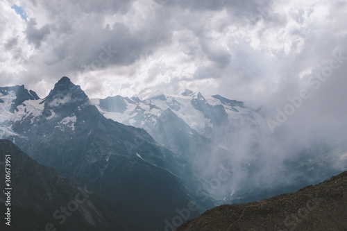 Mountains scene with dramatic cloudy sky in national park of Dombay © TravelFlow