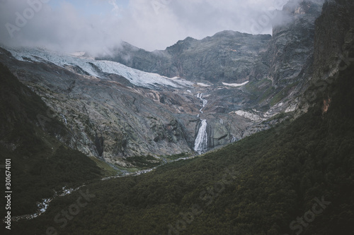 Panorama view on mountains scene and away waterfall in national park of Dombay