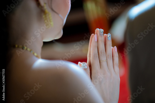 Beautiful Asian girl to pay respect and praying Buddhism worshiping Buddha statue with faith. Hands begging, put your hands together in a prayer position.