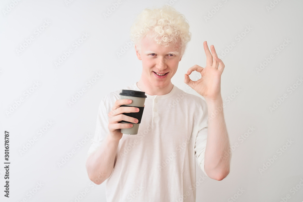 Young albino blond man drinking coffee standing over isolated white background doing ok sign with fingers, excellent symbol Young albino blond man drinking coffee standing over isolated white background doing ok sign with fingers, excellent symbol