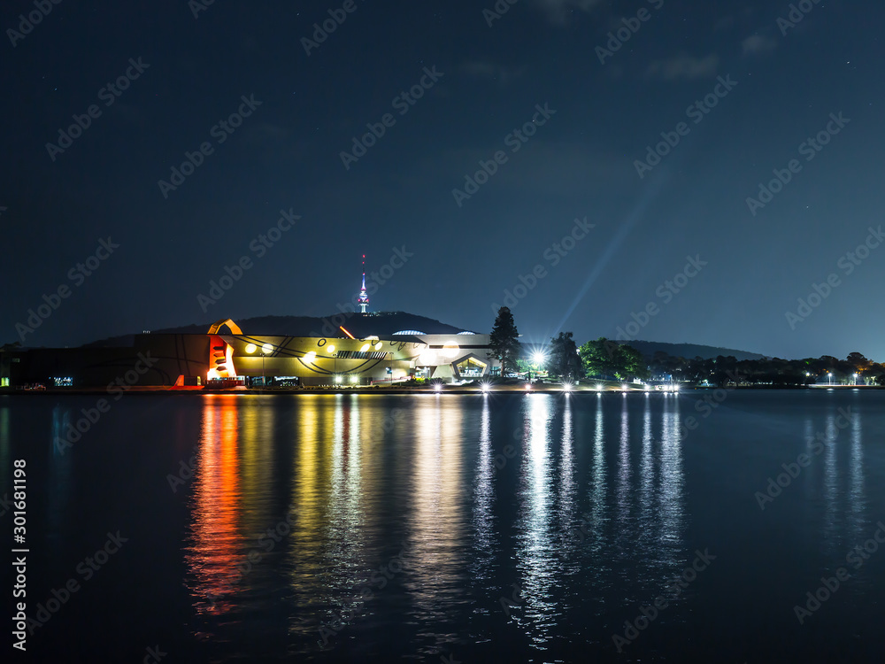 View of the National Museum at night looking over Lake Burley Griffin in Canberra, the capital city of Australia