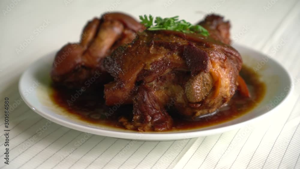 Stewed pork leg in gravy soup on plate Stewed pork leg in gravy soup on plate