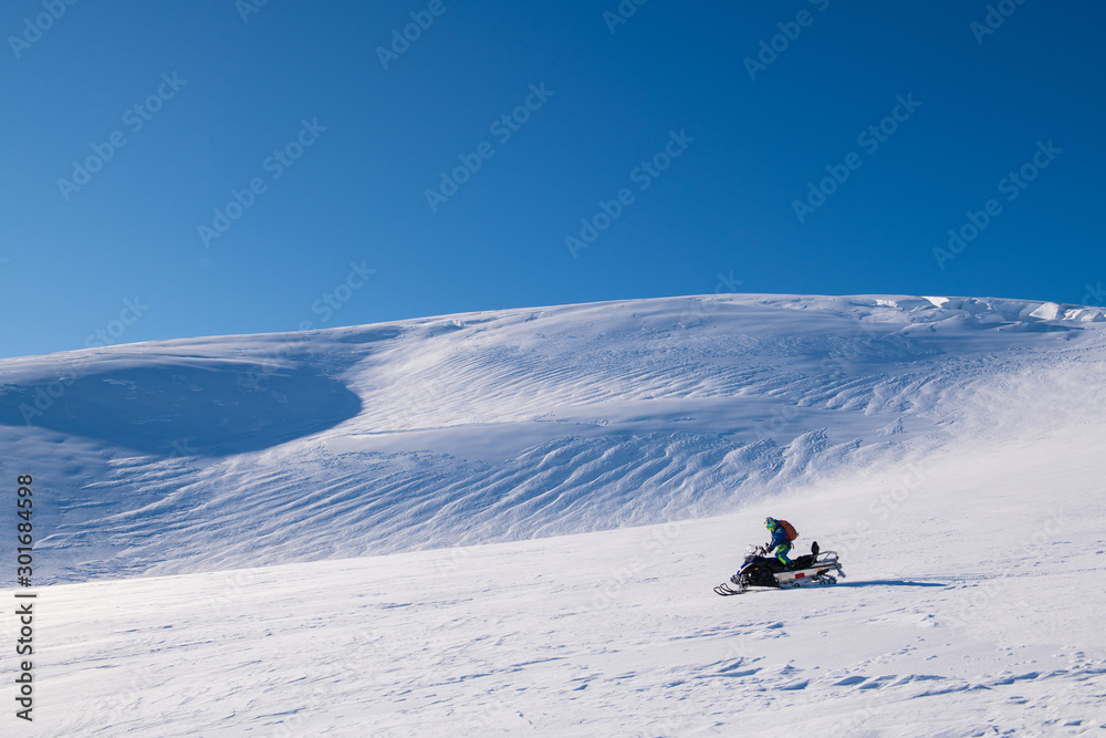 A man drive  snowmobile  in a sunny day, Iceland
