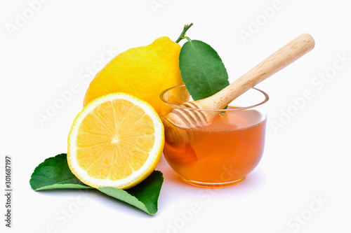 Closeup fresh yellow lemon lime fruit with green leaf and cut in half slice and glass of honey isolated on white background with clipping path. Beauty and spa,skin care,natural herbal plant concept.  photo