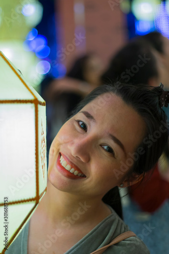 Portrait of Asian woman holding a traditional paper lantern during Yi peng (or Yee peng) festival in Thapae Gate Chiangmai photo