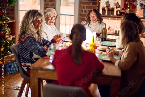 Beautiful group of women smiling happy and confident. Eating roasted turkey celebrating christmas at home