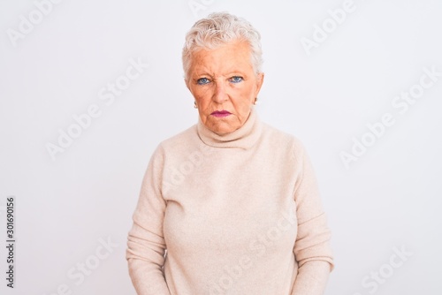 Senior grey-haired woman wearing turtleneck sweater standing over isolated white background depressed and worry for distress, crying angry and afraid. Sad expression.