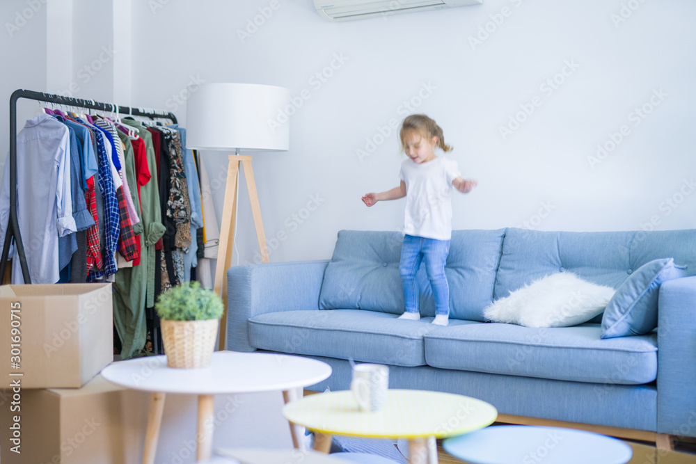 Beautiful toddler child girl jumping on the sofa Beautiful toddler child girl jumping on the sofa