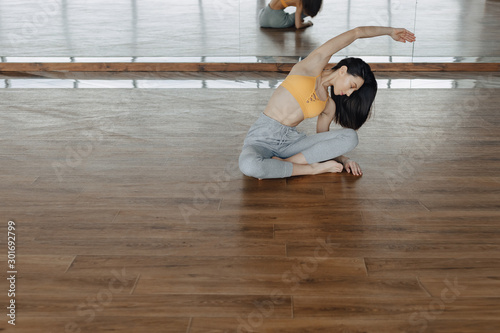 young attractive girl on a wooden floor doing yoga, stretching and relaxing