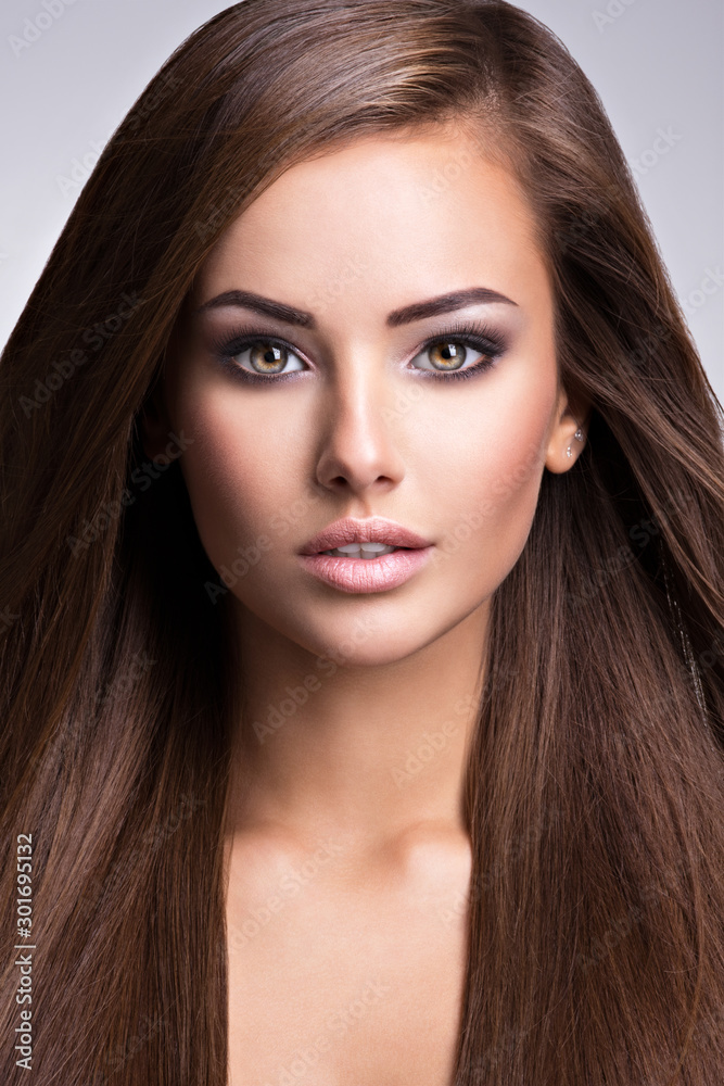 Naklejka premium Portrait of Beautiful young woman with long straight brown hair.