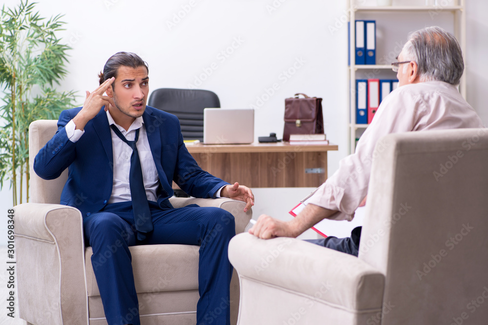 Young man visiting old male doctor psychologist Young man visiting old male doctor psychologist