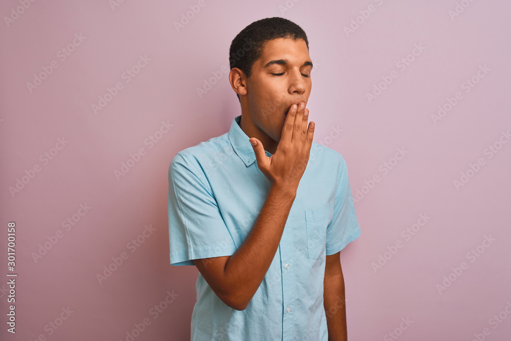 Young handsome arab man wearing blue shirt standing over isolated pink background bored yawning tired covering mouth with hand. Restless and sleepiness. Young handsome arab man wearing blue shirt standing over isolated pink background bored yawning tired covering mouth with hand. Restless and sleepiness.