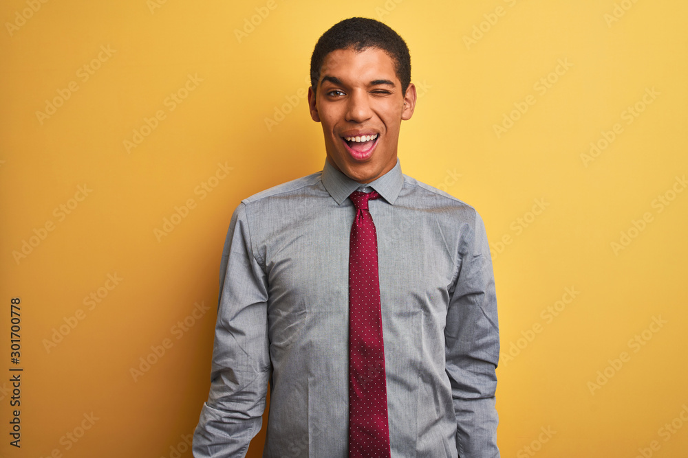 Young handsome arab businessman wearing shirt and tie over isolated yellow background winking looking at the camera with sexy expression, cheerful and happy face. Young handsome arab businessman wearing shirt and tie over isolated yellow background winking looking at the camera with sexy expression, cheerful and happy face.