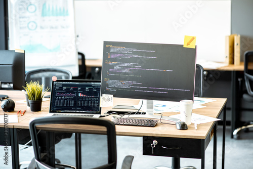 Obraz w ramie Programmer's working place with computers and programming code on the monitors in the office