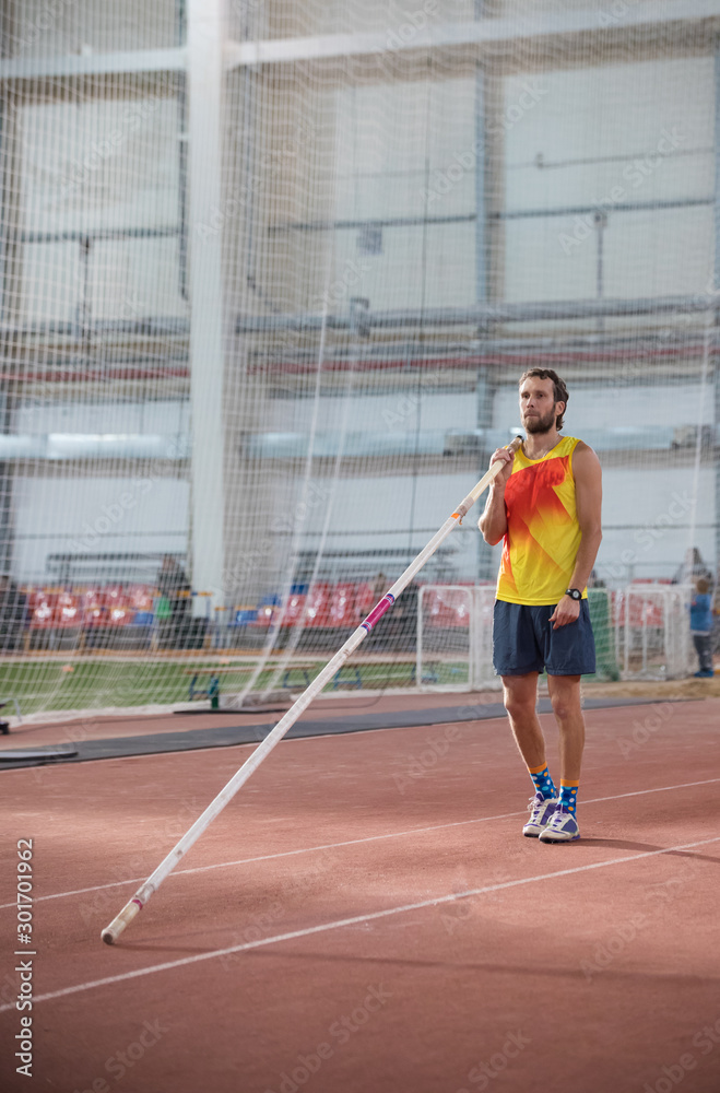 Pole vaulting - man with a beard is standing with a pole