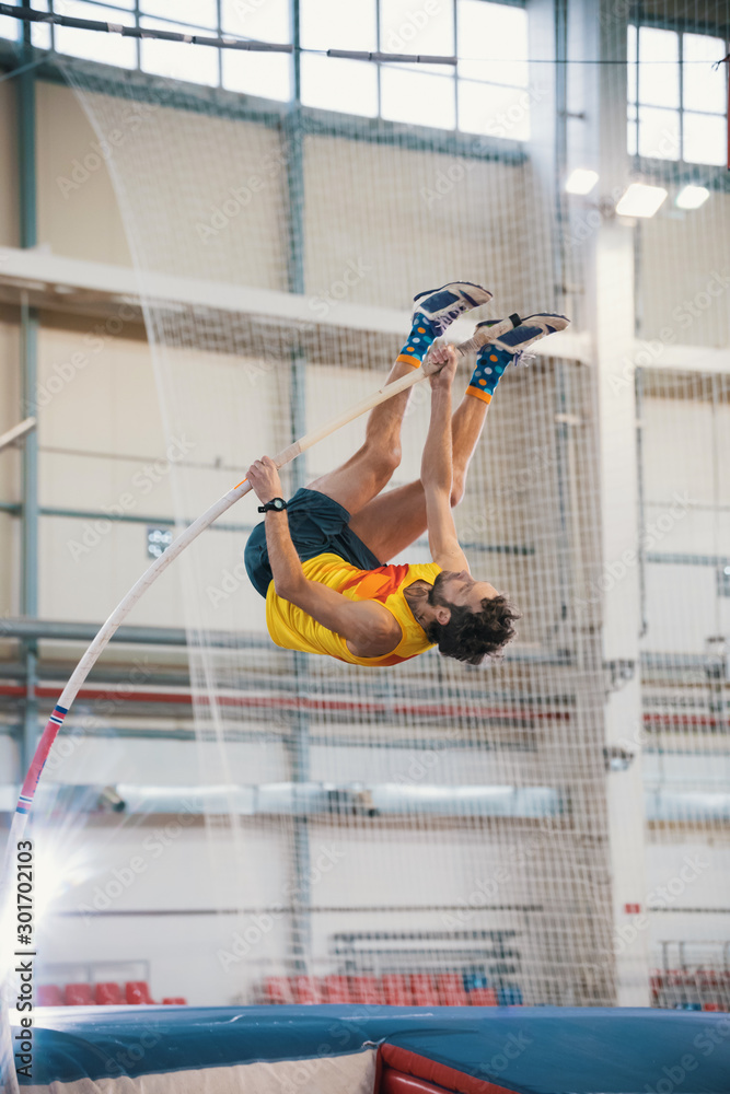 Pole vaulting - man is reaching the bar on the pole