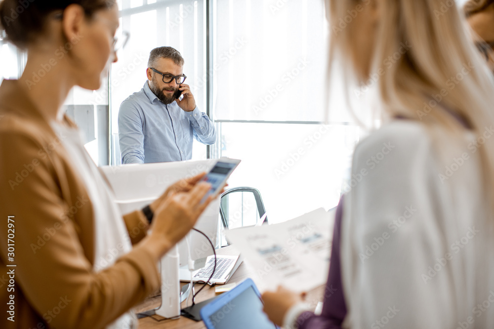 People working in the office, senior manager having a serious conversation on the phone People working in the office, senior manager having a serious conversation on the phone