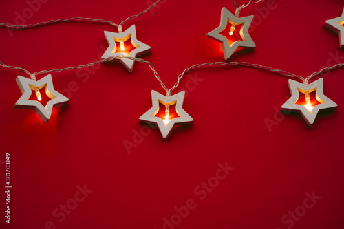 Illuminated star shaped garland on color background close up