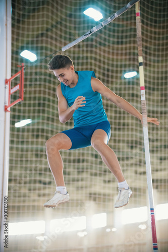 Pole vaulting - man is falling after a jump with a pole and smiling