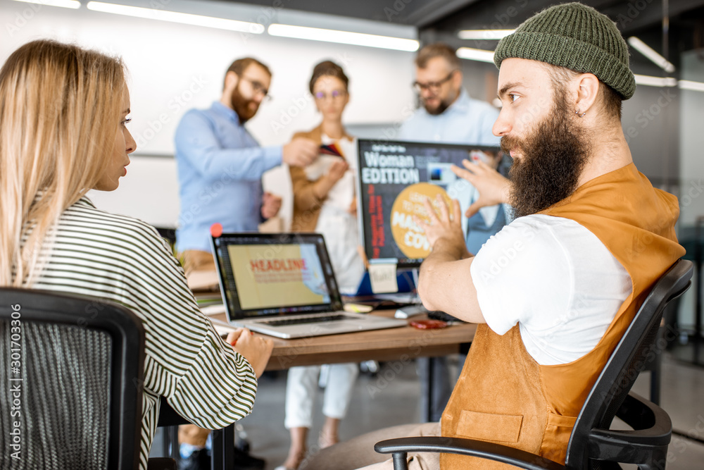 © rh2010 - Group of diverse creative people working as a web designers in the modern office, young couple designing on the computer