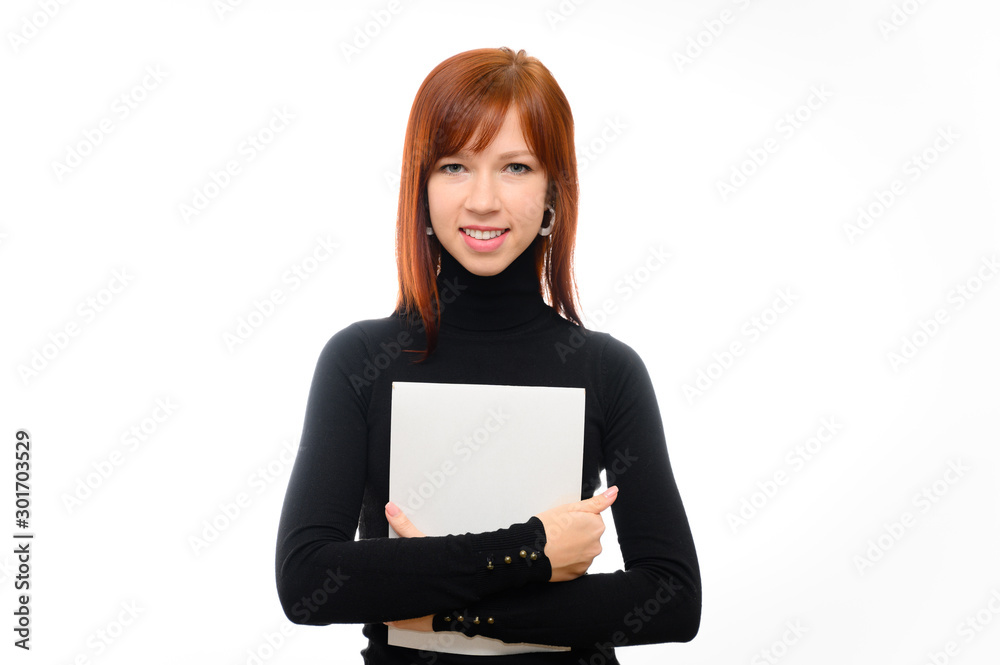 Portrait of a pretty red-haired student girl with long straight hair on a white background in a black sweater with a folder in her hands. Talking, showing emotions, smiling. Portrait of a pretty red-haired student girl with long straight hair on a white background in a black sweater with a folder in her hands. Talking, showing emotions, smiling.