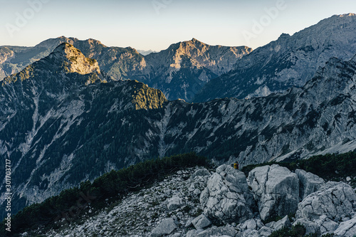Beautiful sunset view of a mountain alpine landscape of Totes Gebirge, Austria. High alpine peaks in yellow and orange evening light. Rocky summit and rock walls of alpine peaks. Blue sky. © Ondra