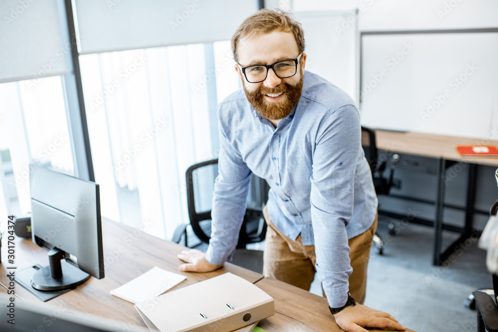Portrait of a handsome bearded office worker dressed casually during a work in the office Portrait of a handsome bearded office worker dressed casually during a work in the office