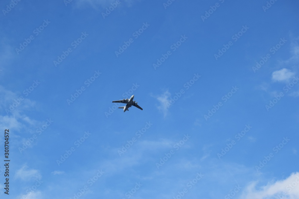 the plane flies away into the distance against the blue sky with white clouds. the dream of traveling to distant countries through the airspace by plane. the plane flies away into the distance against the blue sky with white clouds. the dream of traveling to distant countries through the airspace by plane.