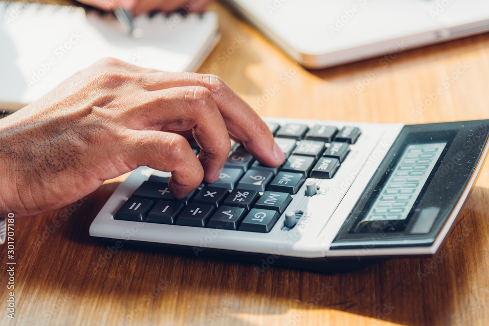 Business man accounting using calculating and work with laptop computer Business man accounting using calculating and work with laptop computer
