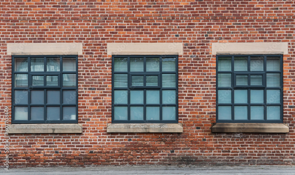 Three vintage windows on the old brick wall.