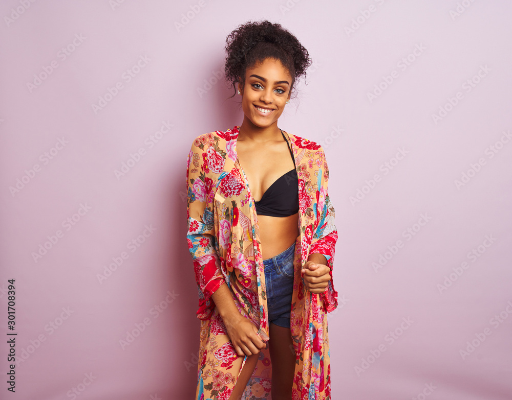 Young beautiful african american woman on vacation standing wearing bikini and colorful caftan Young beautiful african american woman on vacation standing wearing bikini and colorful caftan