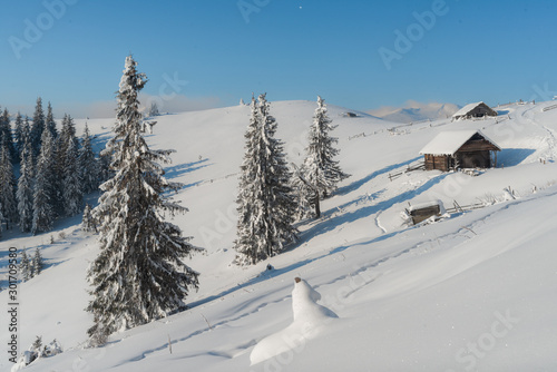 Fantastic winter landscape with wooden house in snowy mountains. Christmas holiday concept. Carpathians mountain, Ukraine, Europe © dvv1989