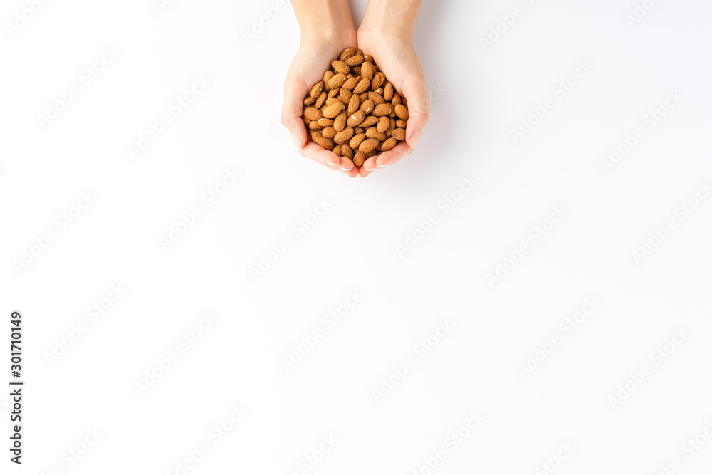 Female hands holding almonds isolated on white background with copyspace. Top view Female hands holding almonds isolated on white background with copyspace. Top view