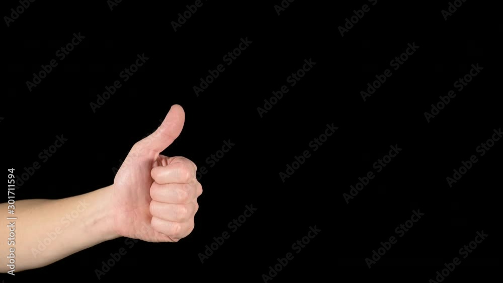 Hand gesture on an isolated black background. The sign is good and bad, like and dislike. A common famous symbol. Man's hand with thumb up and down. Fist with finger close up. The concept of choice. Hand gesture on an isolated black background. The sign is good and bad, like and dislike. A common famous symbol. Man's hand with thumb up and down. Fist with finger close up. The concept of choice.