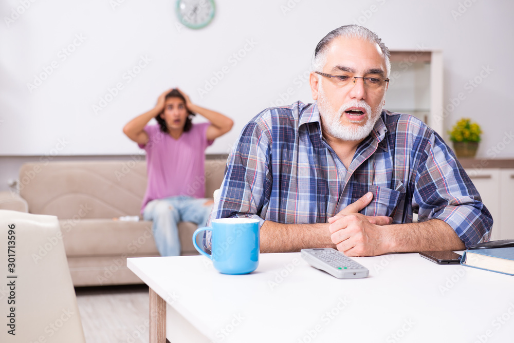 Young student and his old grandpa at home Young student and his old grandpa at home