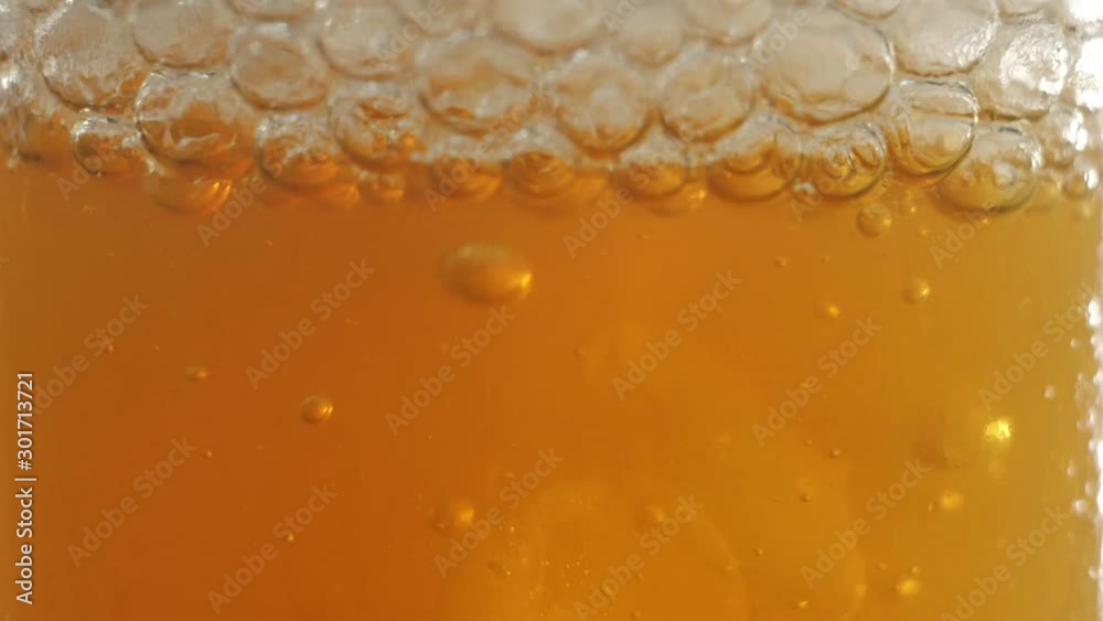 Tea ceremony. Bubbles pop up into a transparent glass with ice cubes, lime slice and mint on table against bright background. Modern cold Chinese ceremony. Close up. Side view Tea ceremony. Bubbles pop up into a transparent glass with ice cubes, lime slice and mint on table against bright background. Modern cold Chinese ceremony. Close up. Side view