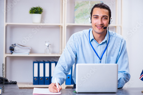 Young male travel agent working in the office