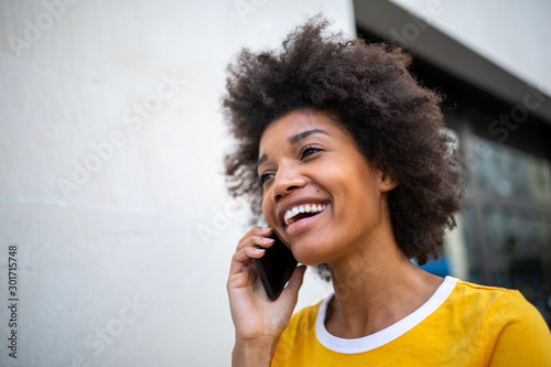 Close up of beautiful smiling african american woman talking on mobile phone