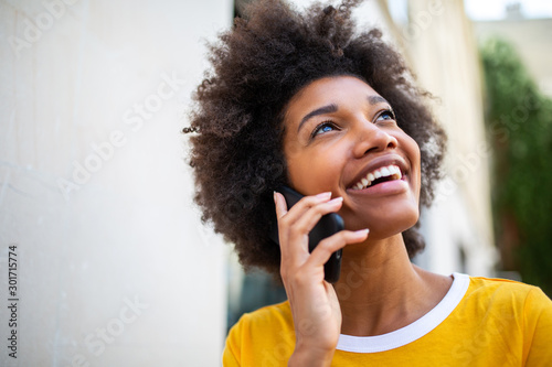 Close up of happy african american young woman talking with cellphone outside