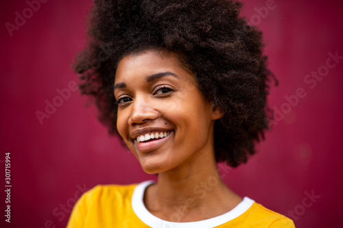 Close up of happy young african american woman smiling by red background