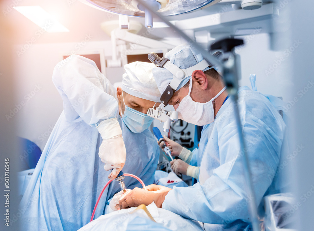 Spinal surgery. Group of surgeons in operating room with surgery equipment. Laminectomy Spinal surgery. Group of surgeons in operating room with surgery equipment. Laminectomy