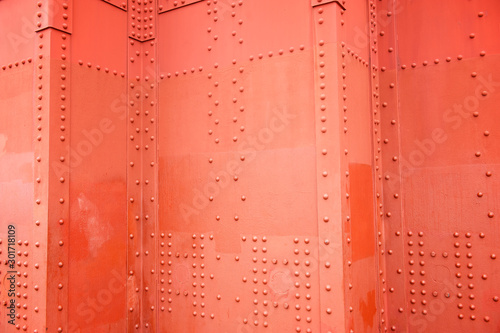 Abstract detail view of the faded International Orange riveted metal panels of a tower on the Golden Gate Bridge in San Francisco, California, USA photo