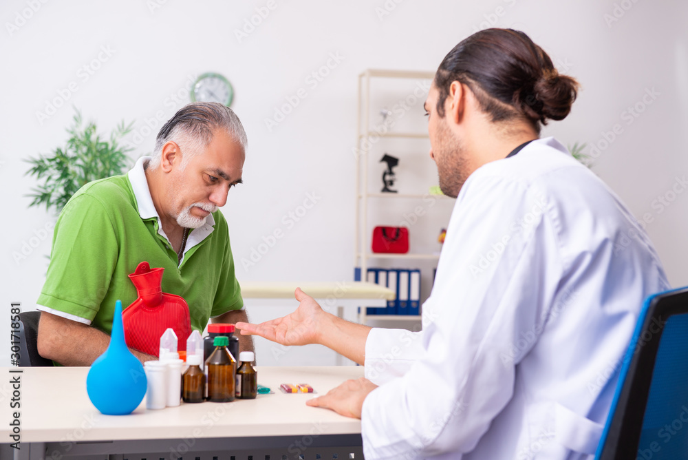 Obraz premium Old man visiting young male doctor gastroenterologist