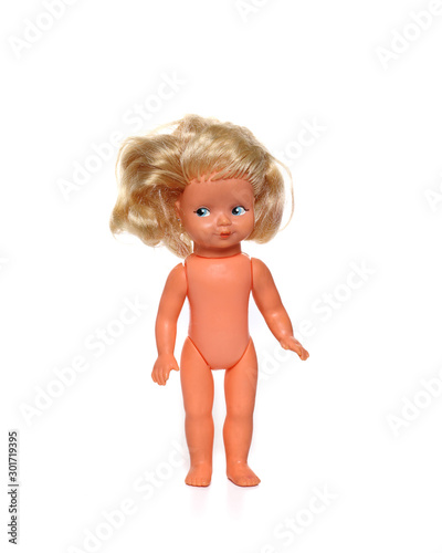 Old plastic baby doll, a toy stands on a white background.