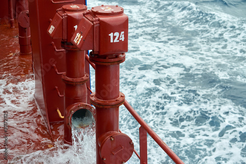 View of Ballast Water exchange process onboard of a ship using flow-through method underway in open ocean. Overflow method through ballast tank air head.