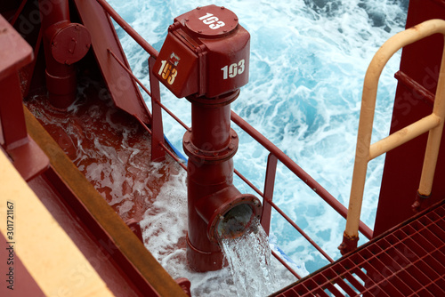 View of Ballast Water exchange process onboard of a ship using flow-through method underway in open ocean. Overflow method through ballast tank air head.