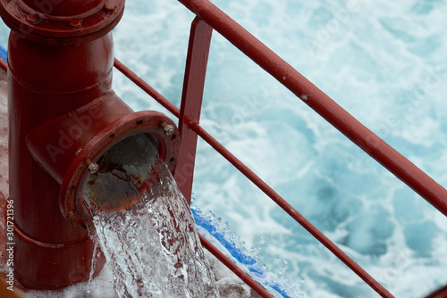 View of Ballast Water exchange process onboard of a ship using flow-through method underway in open ocean. Overflow method through ballast tank air head.