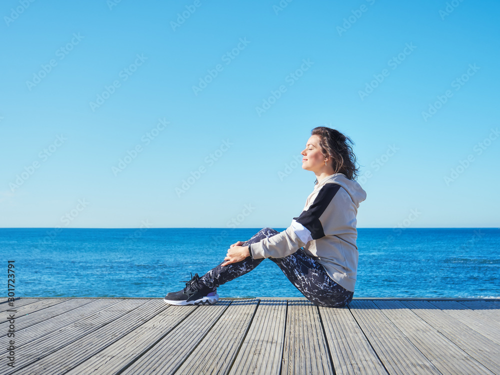 Woman on a wooden pier. Yoga, sport, vacation and freedom concept.