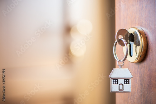 Home key with house keyring in the door keyhole